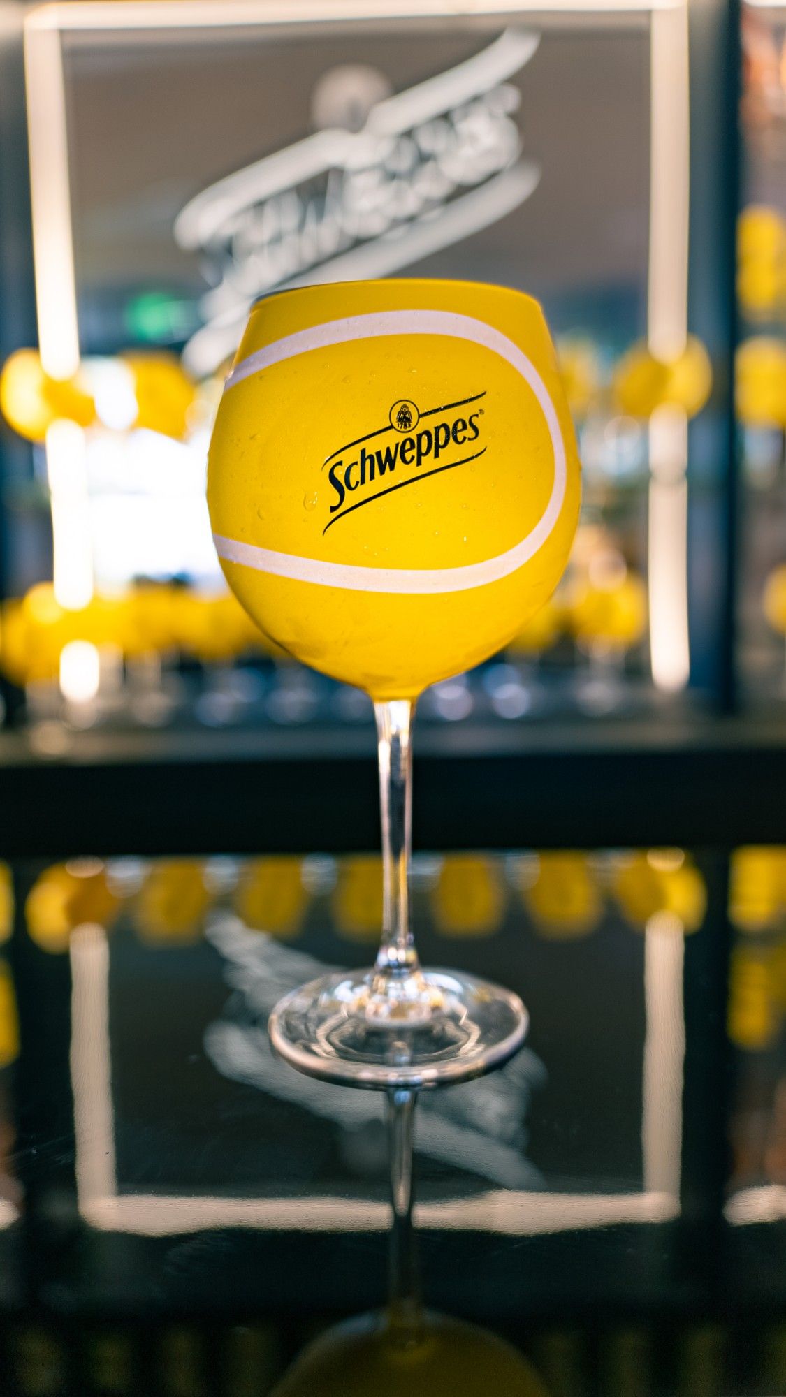 Schweppes tennis-ball glass on the bar, portrait shoot